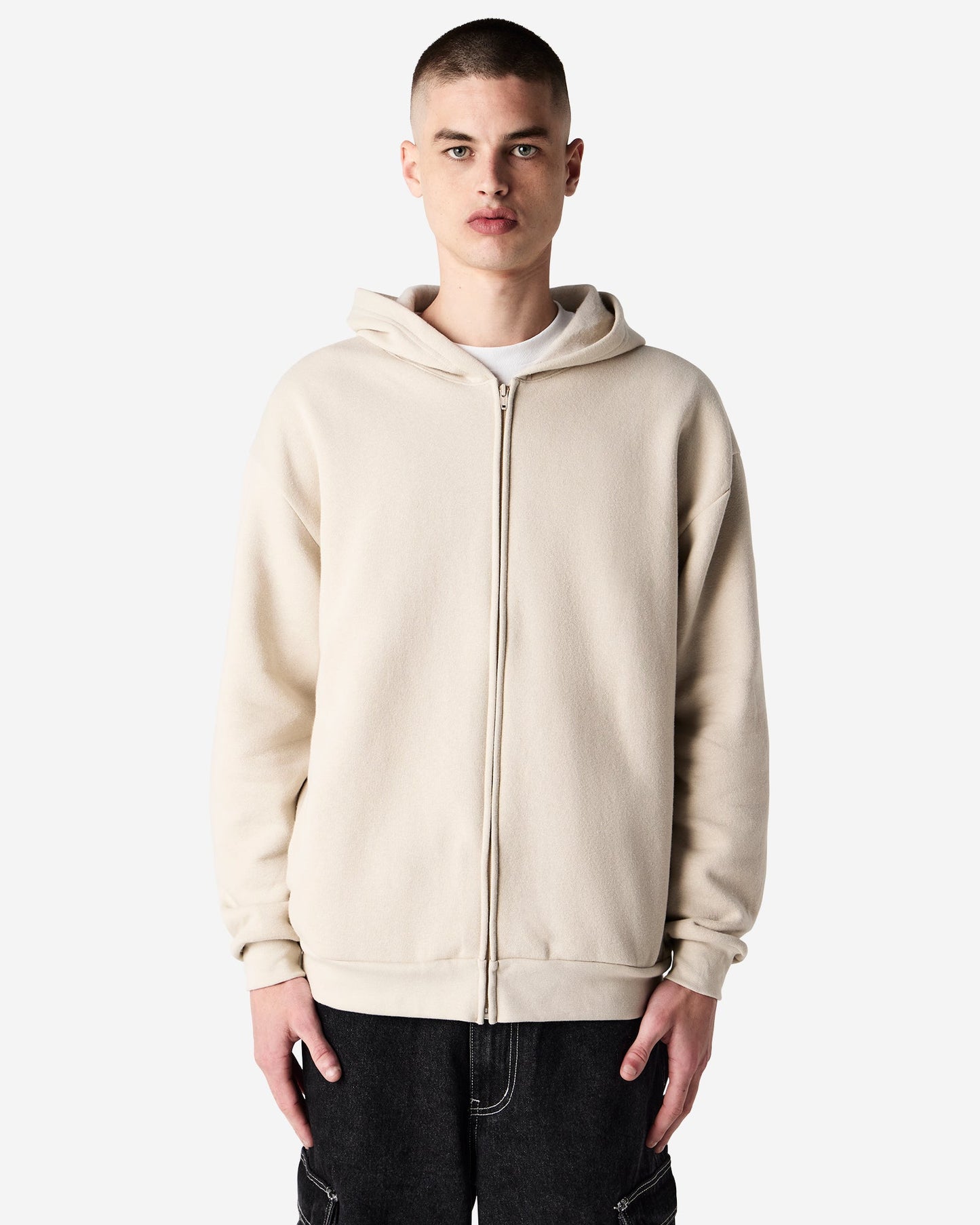 Front close-up view of male model wearing bone-colored American Apparel RF497 zip hoodie, highlighting the minimalistic design and fit-bone