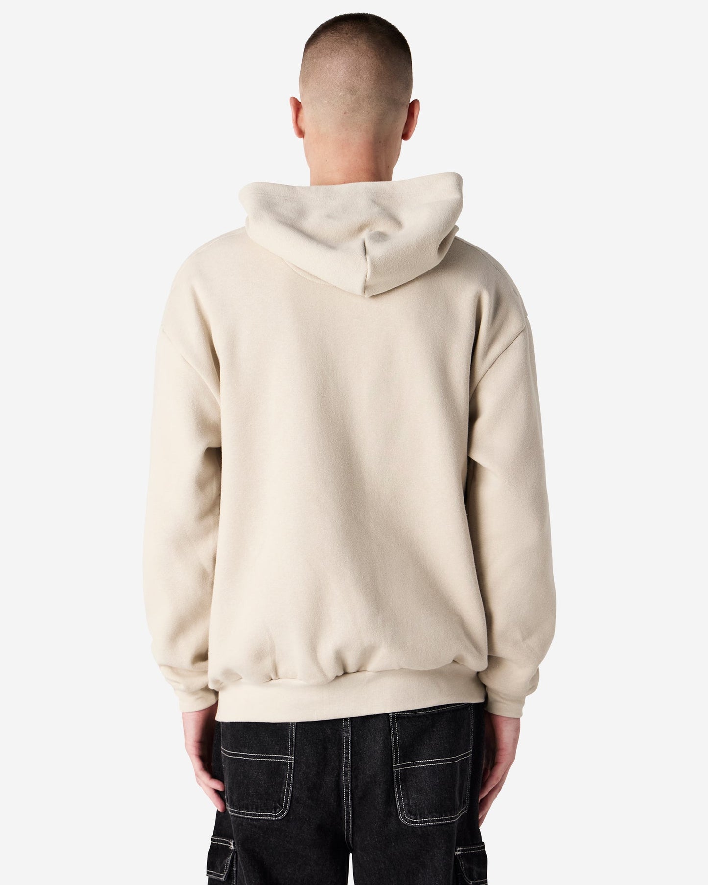 Back view of male model wearing bone-colored American Apparel RF497 zip hoodie, showing the hood and relaxed silhouette-bone